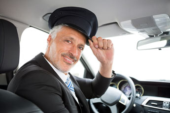 limousine chauffeur tipping hat to back seat